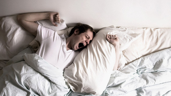Young man waking up --- Image by © Patricia Curi/Corbis